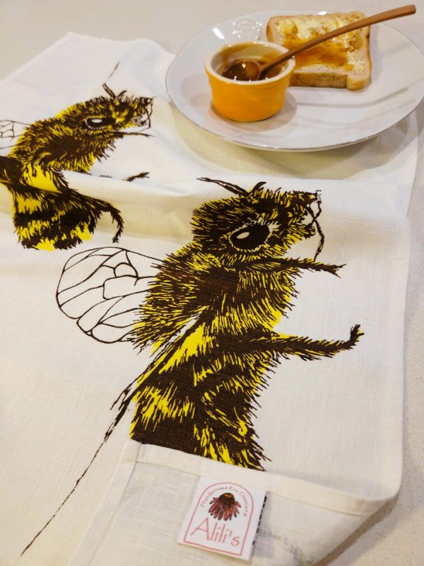 Detail of honey bee design on linen tea towel