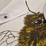 Tea towel hanging in kitchen with hand-printed honey bees