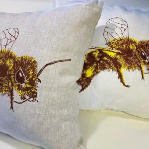 Hand screen-printed linen cushion cover with a honey bee design.